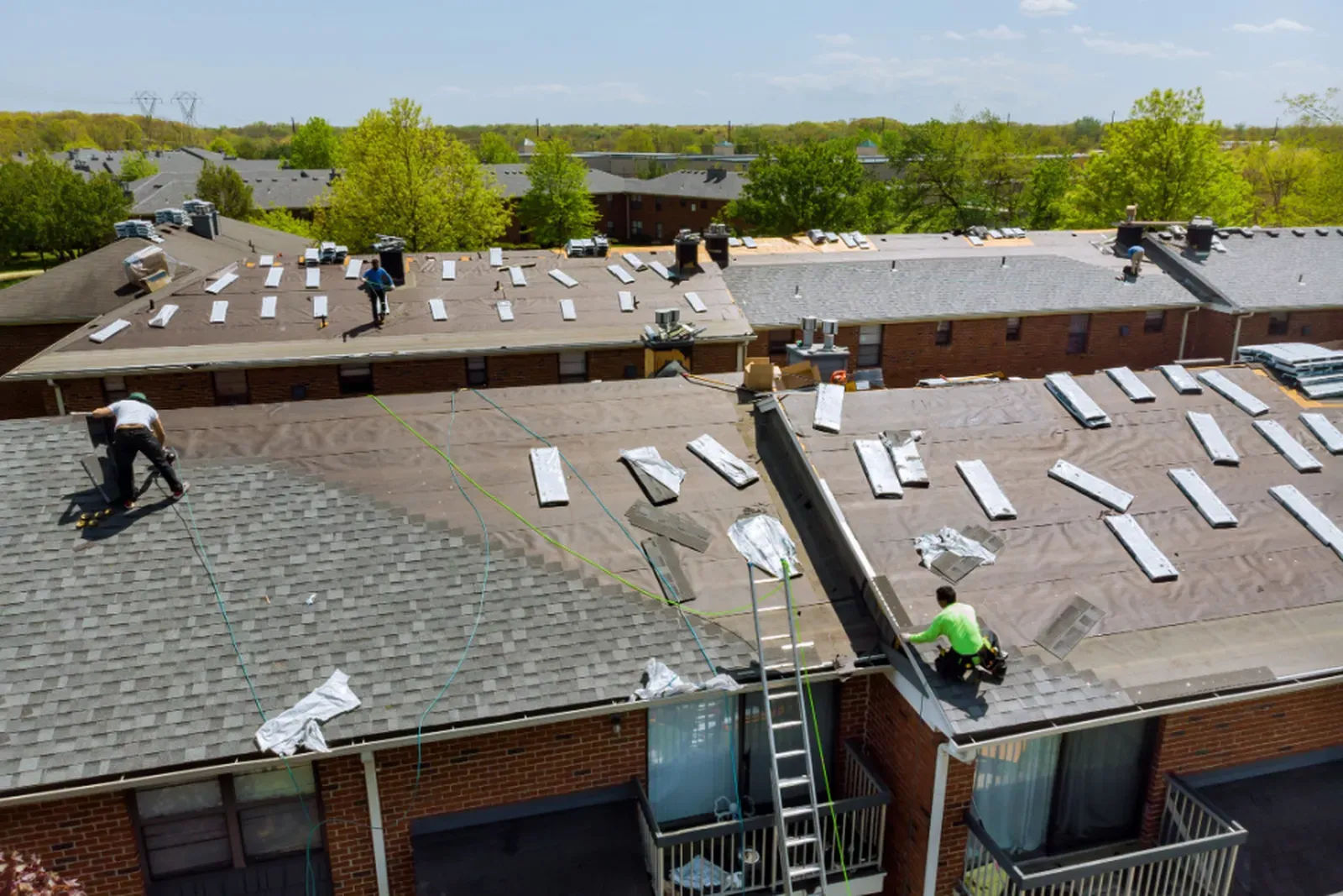 A new asphalt roof being installed on a multifamily building. | You First Home Services