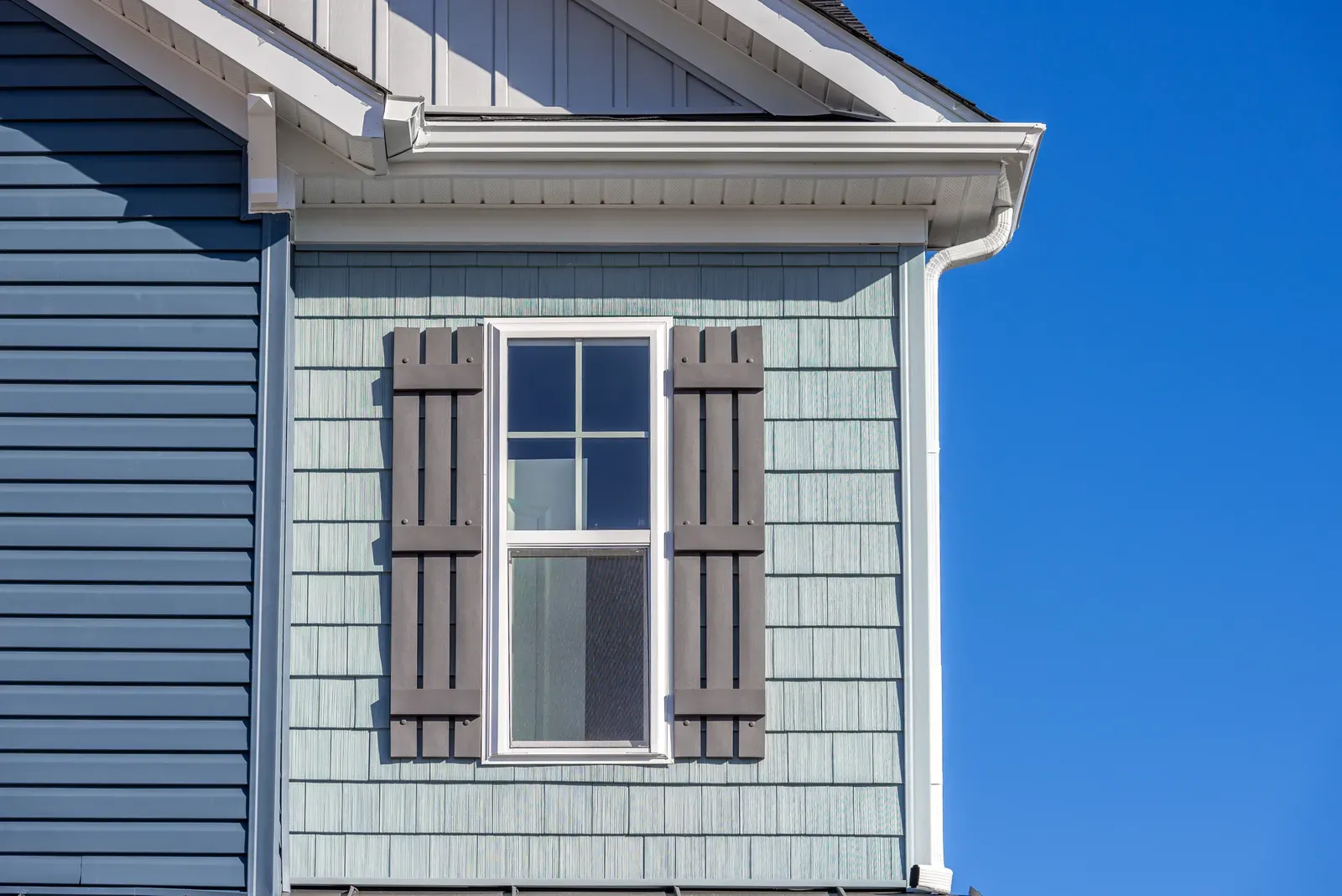 A residential exterior with new siding being installed or replaced, featuring shingle-style siding, approved by a hero. | You First Home Services