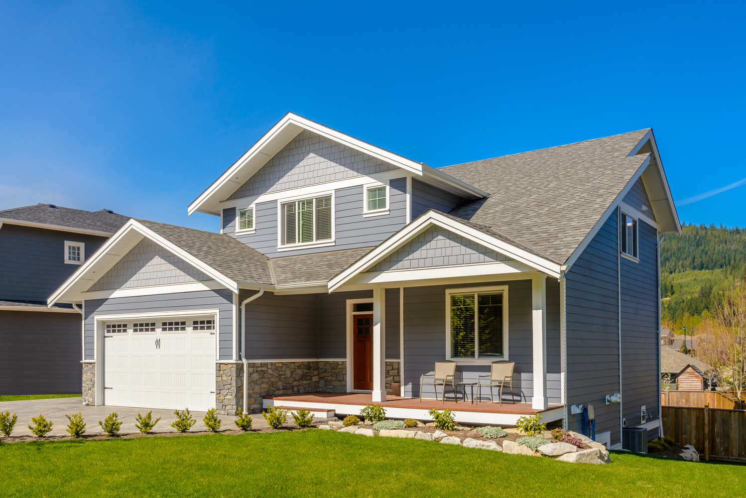 A residential home undergoing exterior renovations, with a new asphalt roof, vinyl siding, sliding windows, and replaced gutters. | You First Home Services