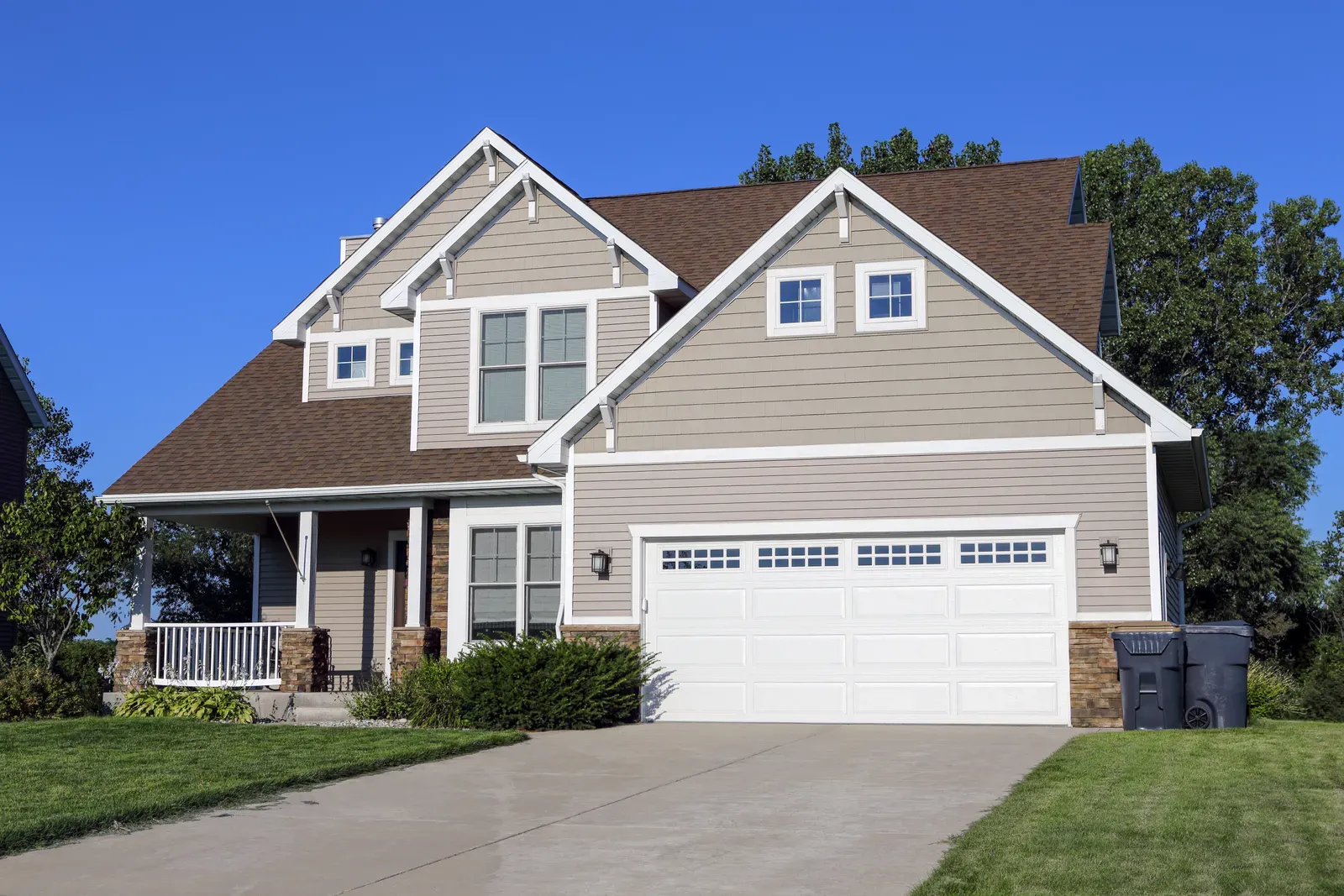 A new vinyl siding being installed on a residential home, approved by a hero. | You First Home Services