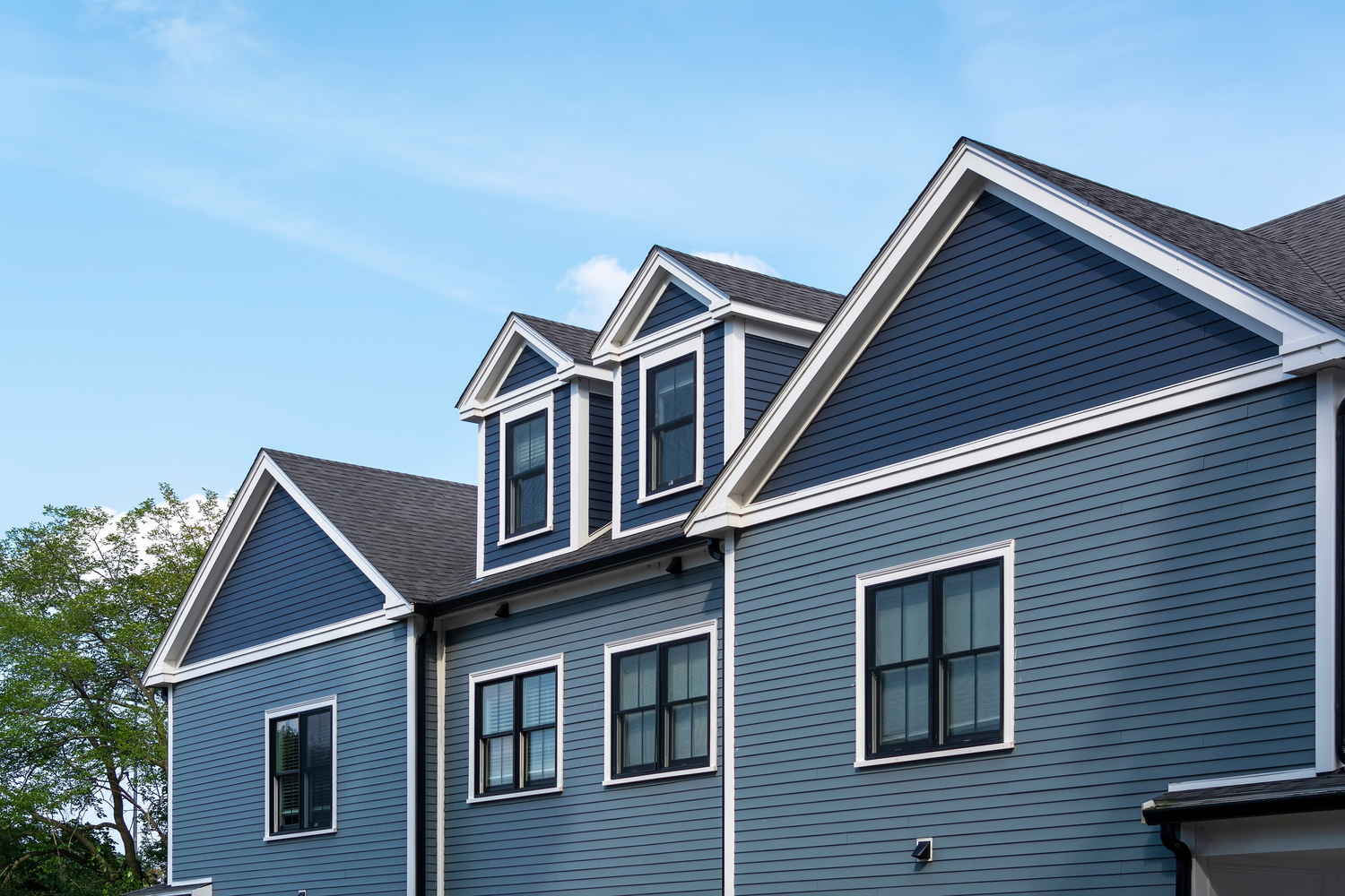 A newly installed vinyl siding and double-hung window on a residential building, hero-approved. | You First Home Services