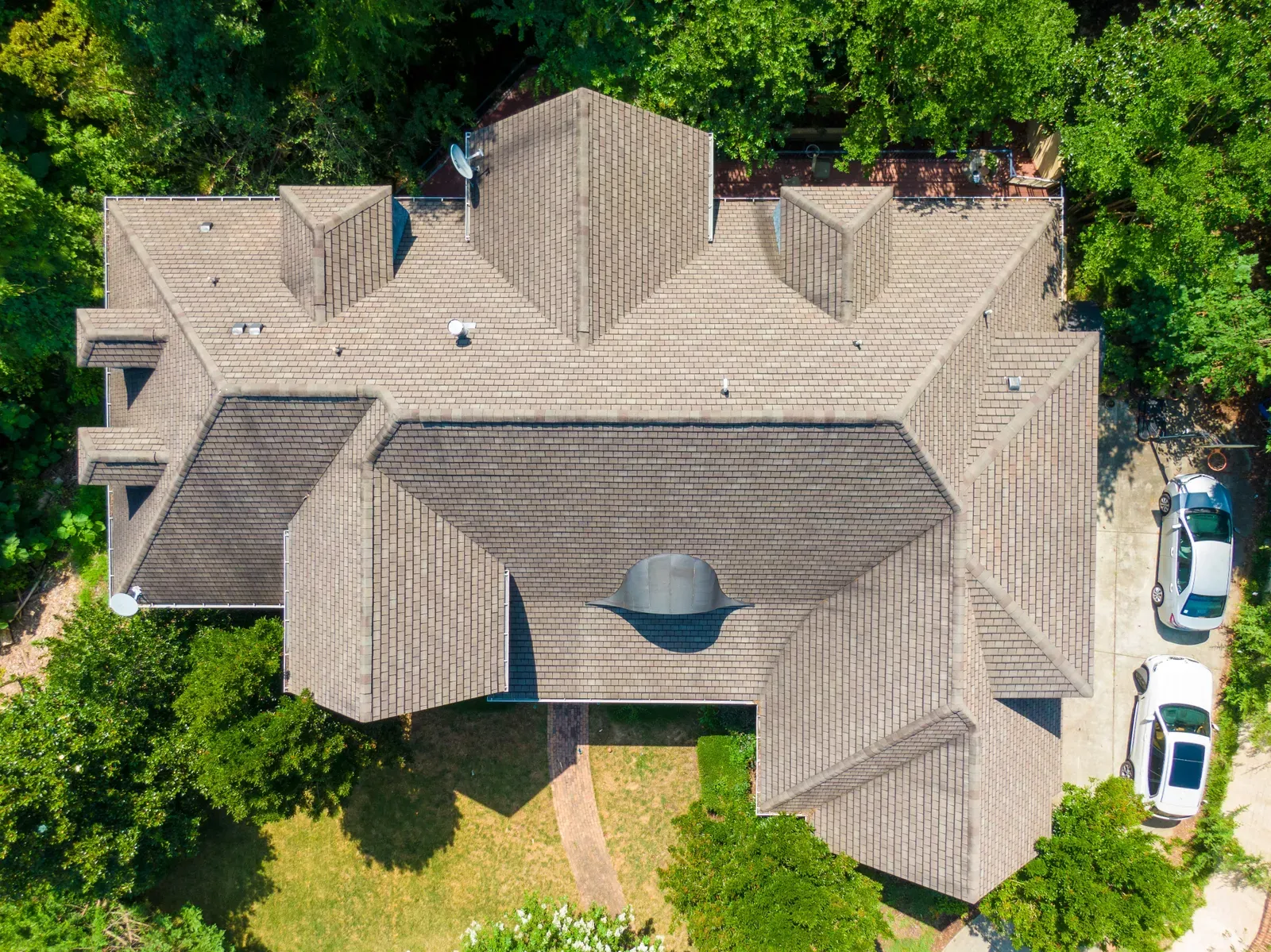 A newly installed asphalt roof on a residential building, approved by a hero. | You First Home Services