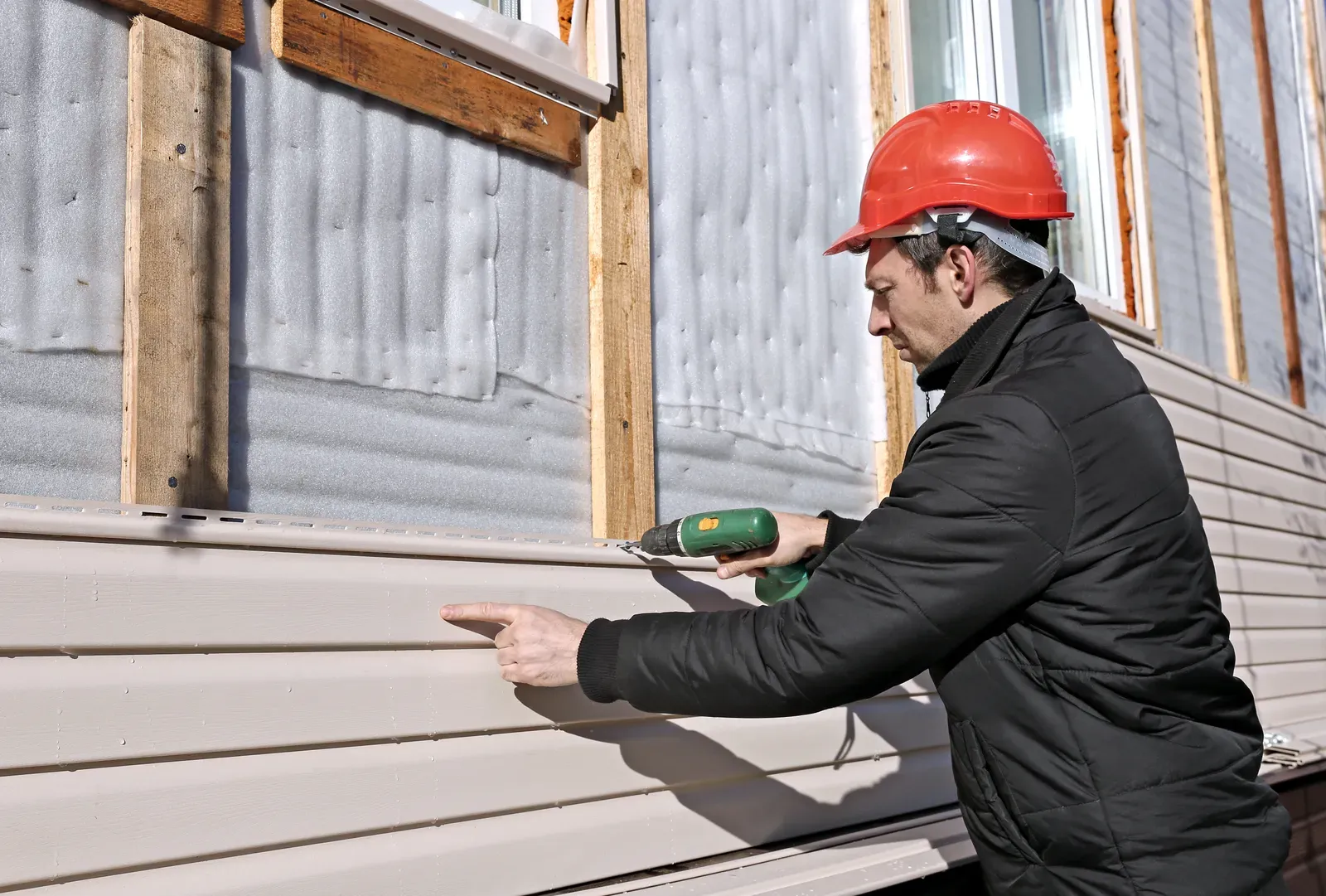 A new vinyl siding being installed on a residential home | You First Home Services